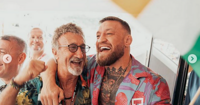 Conor McGregor hugs Eddie Jordan while waving Irish flag at Monaco F1 Grand Prix