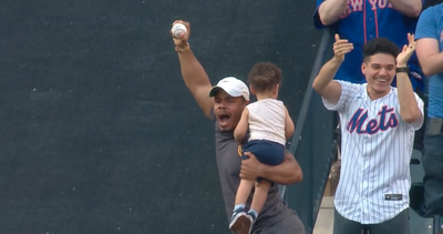 A Mets fan dangerously snagged a home run one-handed off a bounce with a child in his other hand