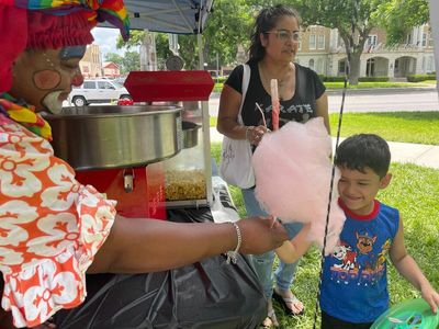 In Uvalde, a woman in clown colors makes kids smile