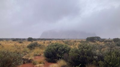 Uluru's waterfalls spring to life as rock disappears into clouds