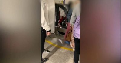 Moment fed-up Manchester Airport passengers climb through baggage carousel curtain to find luggage as armed cops step in
