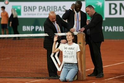 French Open semi-final interrupted as protester ties herself to net