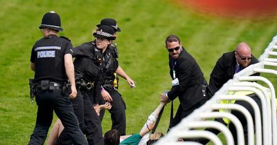 Protesters dressed as suffragettes run onto the track at Epsom Derby