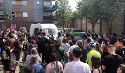 Crowd chanting ‘let him go’ stops officers taking away man accused of immigration offences by blocking van