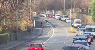 Watch as Edinburgh man walks up bike lane 'throwing things at random cars'