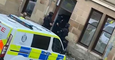 Armed cops storm Scots flat block as three people rushed to hospital after attack