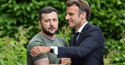 Zelensky looks grim-faced as Macron leans in for an awkward hug in Kyiv