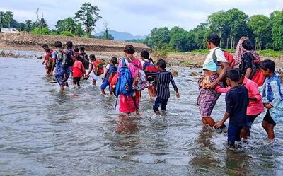 Off to school through swirling waters