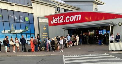 Passengers left sitting on 'absolutely rammed' airport floor causing massive queues