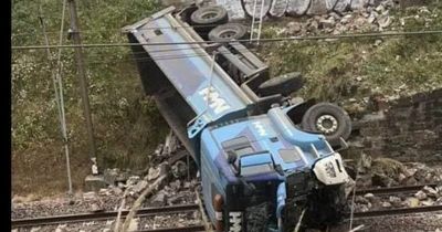 Lorry crashes through wall onto Scots train tracks as emergency services rush to scene