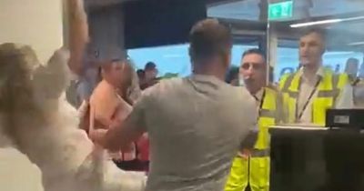 Shocking moment raging holidaymaker fights airport workers and knocks girlfriend over