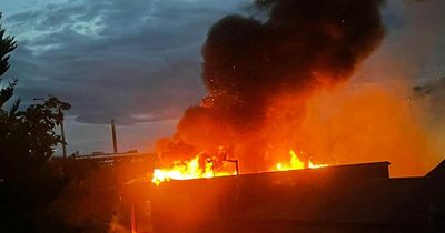 Huge warehouse fire rages into night as people told to keep windows closed