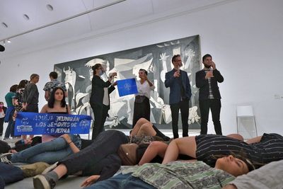NATO summit protesters play dead in front of Picasso war painting