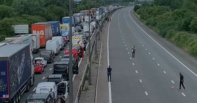 People get out of their cars and play football on the M4 as traffic is stopped during fuel protests