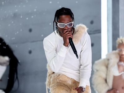 Travis Scott halts concert to order fans to stop dangling from lighting truss amid safety concerns