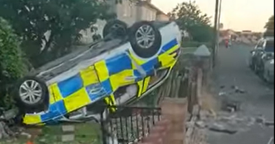 Police car ends up on its roof in garden after crash