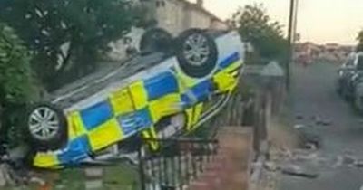 Police car flips over and crashes into garden as dramatic footage captures aftermath
