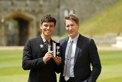Tom Daley receives OBE as Olympic champion diver poses with husband Dustin Lance Black at Windsor Castle