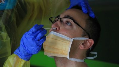 New Zealand offering free masks, tests to all as health system struggles with COVID-19