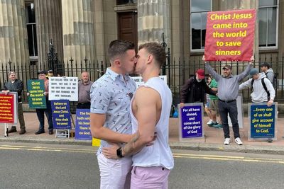 Gay couple share kiss in front of homophobic protesters at Pride event