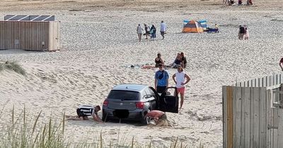 Red-faced BMW driver gets stuck on beach in heatwave after ignoring 'no cars' sign