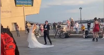 Newly married couple beam as they dance outside Liver Building