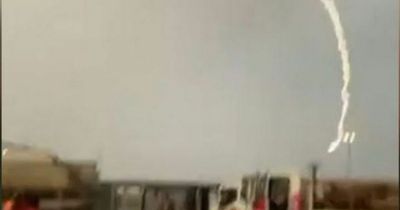 Powerful lighting strike sends workers running as thunderstorm warning issued