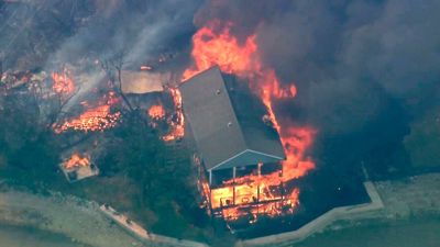 Wildfire burns homes around lake in Texas amid high heat