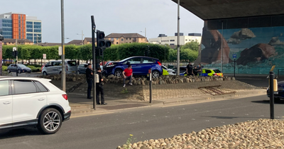 Driver mounts pavement at busy Glasgow junction leaving car stuck on rocks