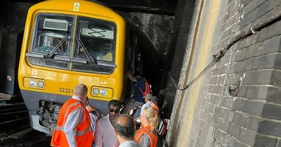 Moment fed up passengers abandon train stuck in tunnel and walk to platform along tracks