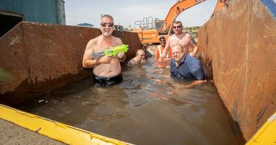 Firm transforms skip into swimming pool to keep staff cool in UK heatwave