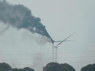 Black clouds fill the sky as wind turbine bursts into flames