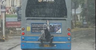 Reckless Edinburgh teen filmed clinging one-handed onto airport bus during rain storm