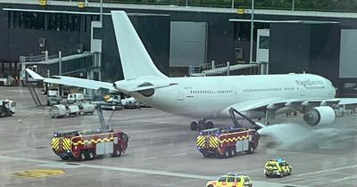 TUI passenger plane catches fire at Manchester Airport as fire crews rush to the scene