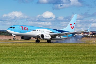 Fire engines surround plane at Manchester Airport as smoke billows from engines