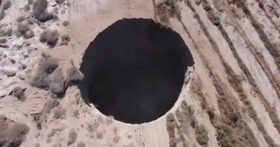 Enormous sinkhole tears open the ground as authorities probe what lurks underneath