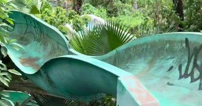 Inside abandoned 'haunted' waterpark with dragon-guarded tower and rusting waterslides
