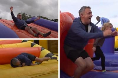 Alex Cole-Hamilton awkwardly bounces around on an inflatable obstacle course