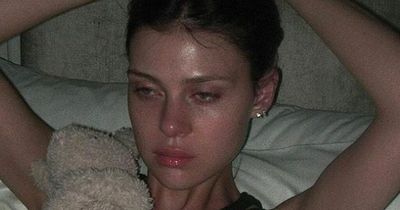 Nicola Peltz breaks down in tears in bed as she reveals her 'heart is hurt'