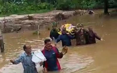 Residents wade through neck-deep water with dead body in Thirthahalli