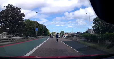 Reckless Edinburgh motorbike rider slaloms traffic and pulls stunts on busy road