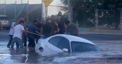 Woman rescued from car seconds before vehicle is swallowed by massive sinkhole