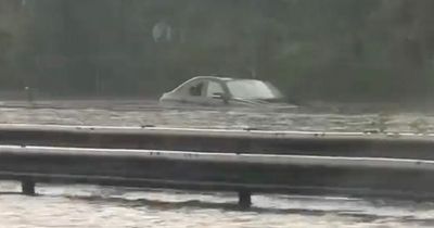 London floods: Watch family forced to break window and abandon car after flash downpour