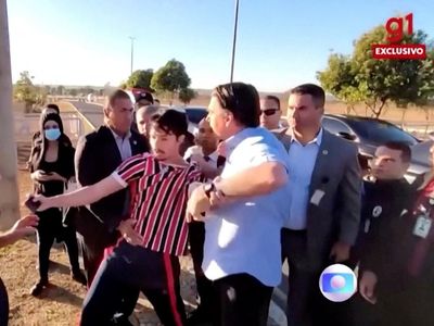 Brazil’s president Jair Bolsonaro grabs at heckler and tries to snatch his phone
