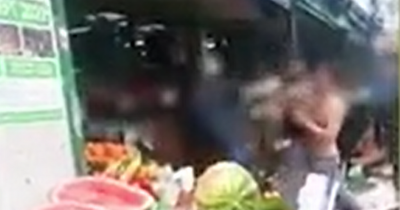 Stacks of fruit hurled into road as huge fight erupts outside Manchester store