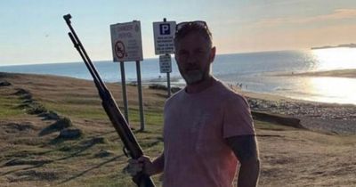 Plaid Cymru councillor pictured posing with rifle to ensure there were no 'English people trying to cross the channel'