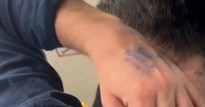 Man sparks outrage after fellow commuters spot 'gutless' reminder written on his hand