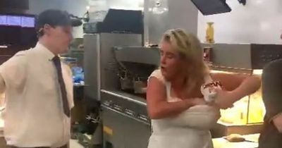 Woman in white dress crams Big Macs down her bra after running into McDonald's kitchen