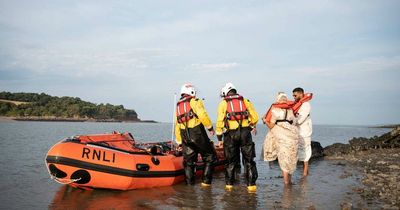 Bride and groom rescued by lifeboat crew after tide cut them off during photoshoot