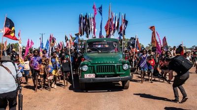 Thousands recreate the Wave Hill walk-off, originally led by Vincent Lingiari, at the Freedom Day Festival in Kalkarindji